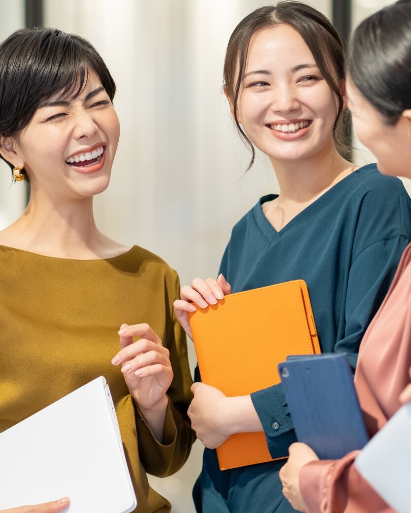 廊下で談笑している3人の女性社員